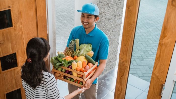 Hình ảnh shipper giao đồ ăn với nụ cười rạng rỡ và thân thiện