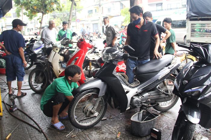 Dòng xe máy bị ngập nước qua đêm, các thợ sửa xe ở Đà Nẵng bận rộn từ buổi sáng - Ảnh 12.