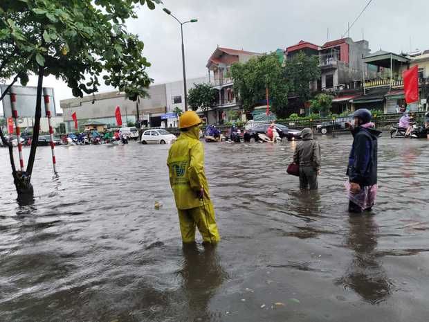 Hình ảnh đường phố Hà Nội biến thành sông sau cơn mưa lớn, khiến bánh xe ngập lụt - Xem Ảnh 12.