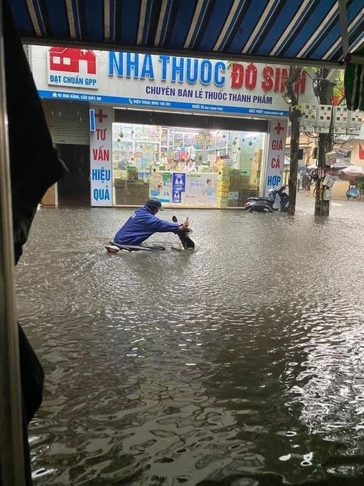 Sau trận mưa lớn, đường phố ở Hà Nội đã chuyển biến thành những dòng sông, làm ngập lụt bánh xe - Xem Ảnh 11.