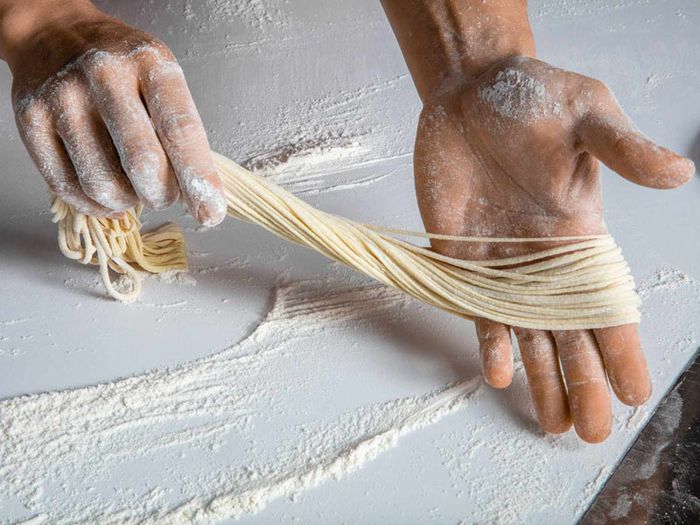 Đầu bếp đang cẩn thận kéo sợi mì siêu dài.