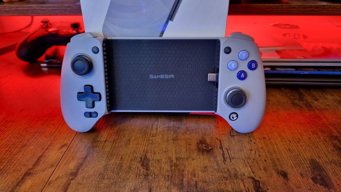 Ảnh đánh giá GameSir G8 Galileo với bộ điều khiển đứng gần hộp của nó, với ánh sáng RGB màu đỏ phía sau