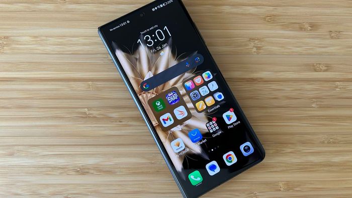 Honor Magic V2 gập lại trên màn hình chính trên một bàn làm bằng gỗ