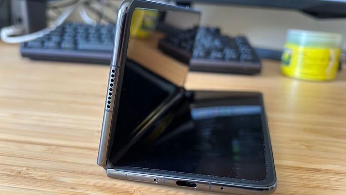 Honor Magic V2 mở một nửa trên một bàn làm từ gỗ