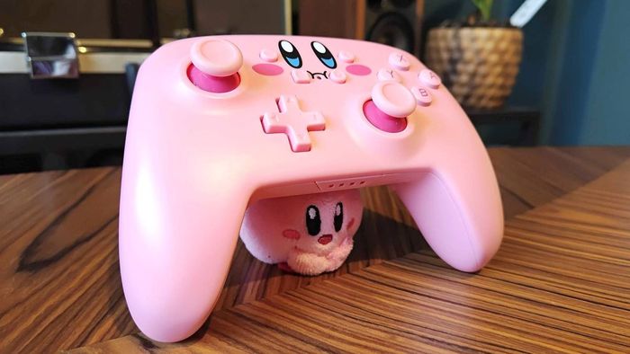 Bộ điều khiển PowerA Kirby được cầm lên bởi con búp bê Kirby