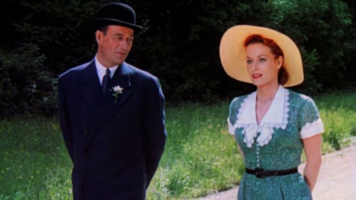 John Wayne và Maureen O'Hara đi dạo trong một vùng quê xanh tươi của Ireland trong trang phục năm 1920 trong The Quiet Man