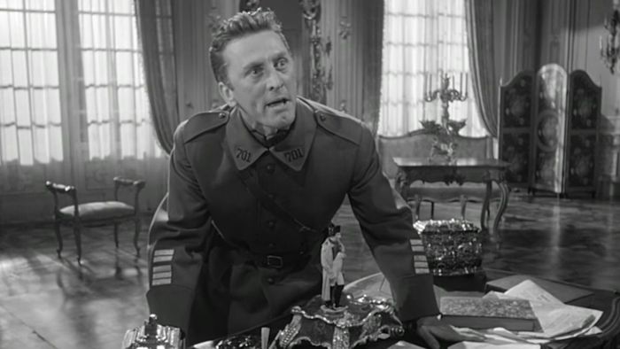 Kirk Douglas trong vai một đại tá chiến tranh thế giới thứ nhất đứng bên bàn làm việc trong Paths of Glory