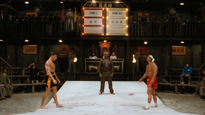 Hai người đứng đối diện nhau trong một sàn đấu võ thuật ngầm trong Bloodsport