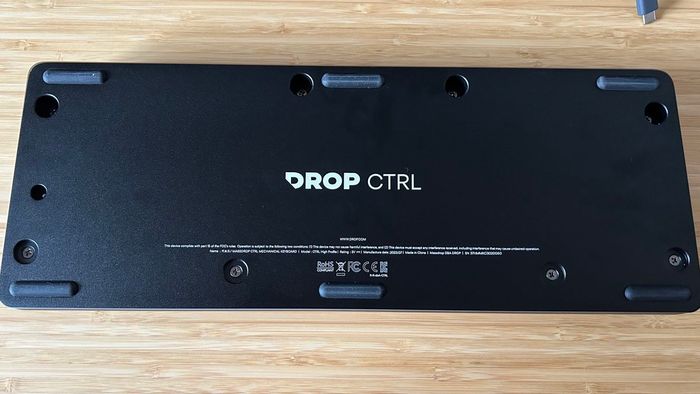 Quay trở lại bàn phím CTRL V2 trên một bàn làm việc gỗ