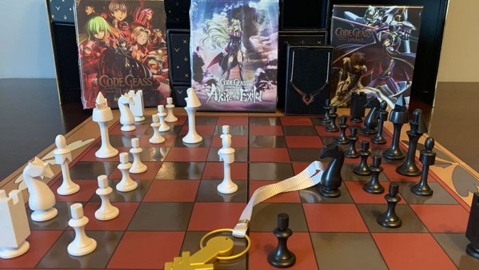 Bản Sưu tầm Code Geass, với bộ cờ, được bày trên một bề mặt gỗ