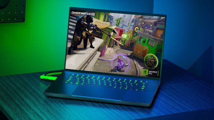 Laptop chơi game Razer Blade 16 trên bàn làm việc với đèn xanh