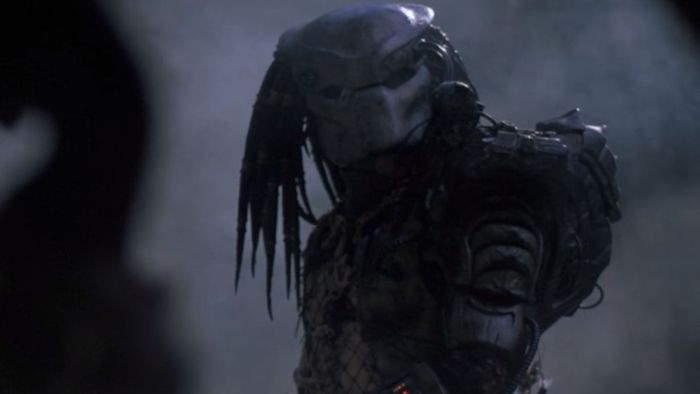 Người ngoài hành tinh Săn Mồi đứng trong một khu rừng mù mịt trong Predator