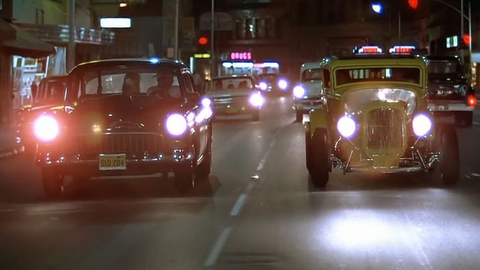 Hai chiếc hot rod chạy qua một con phố nhỏ trong American Graffiti