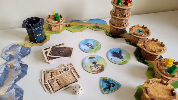 Các thành phần, thẻ và gạch của Wandering Towers trên một bề mặt màu trắng