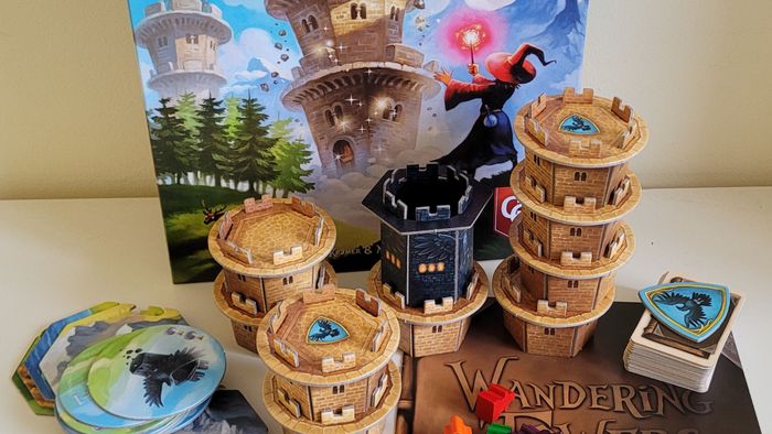 Hộp, token, quy tắc, và các thành phần của Wandering Towers trên bề mặt trắng