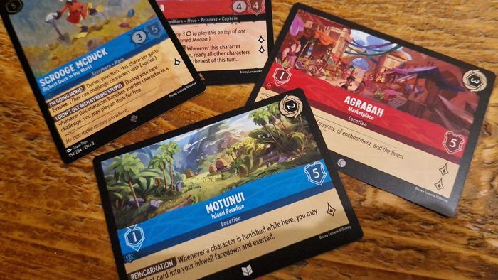 Một bộ sưu tập các lá bài Disney Lorcana Into the Inklands trên một bàn gỗ