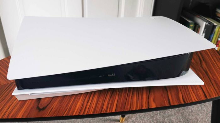 Một chiếc máy console PS5 trên một bàn gỗ