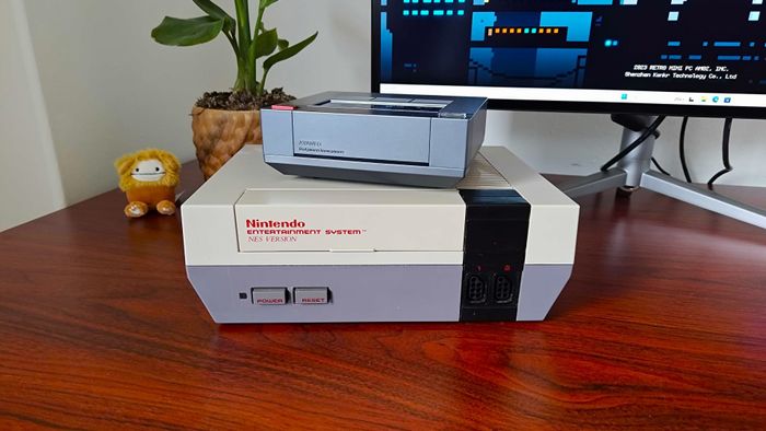 Ayaneo Mini PC AM02 đặt trên bàn điều khiển NES