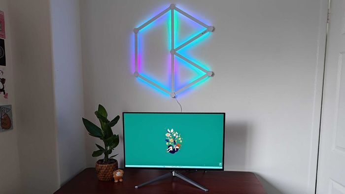 Bộ kit Nanoleaf Lines được gắn vào tường bên cạnh bố trí bàn chơi game