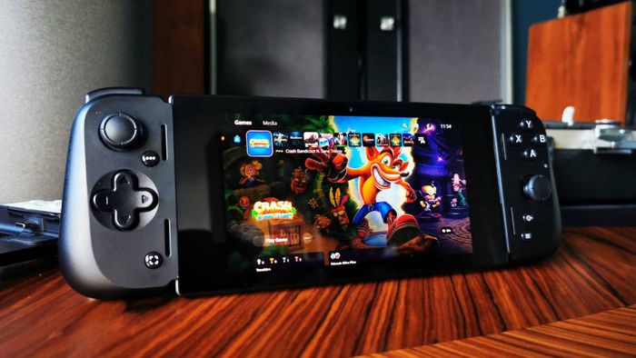 Razer Edge handheld hiển thị menu chính của PS5 trên màn hình với Crash Bandicoot N-Sane Trilogy được chọn