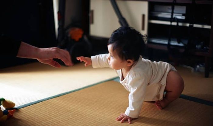 Hãy khuyến khích trẻ di chuyển đến gần bạn khi bé tập bò. Nguồn: Getty Images.