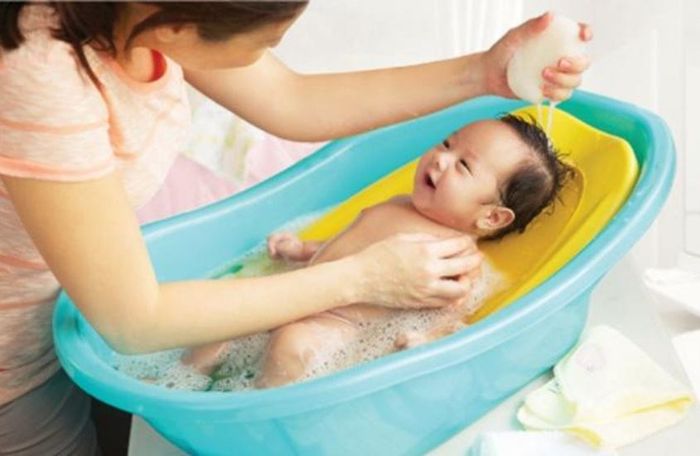 Sử dụng khăn xô thấm nhẹ lên cơ thể bé