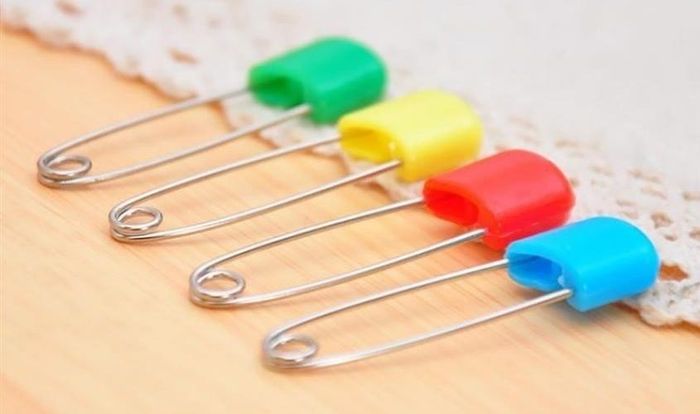 Cẩn thận khi sử dụng kim băng để cố định tã vải trên cơ thể của bé