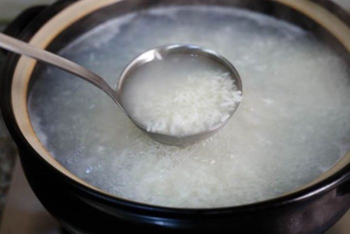 Nấu cháo trắng để chuẩn bị nấu món cháo cá hồi cải bó xôi