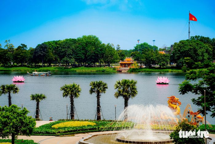 Các đóa hoa sen khổng lồ trên dòng sông Hương, trước bến Nghinh Lương Đình. Phía xa xa là Kỳ Đài, trước cung điện Hoàng cung Huế uy nghi - Ảnh: LÊ ĐÌNH HOÀNG