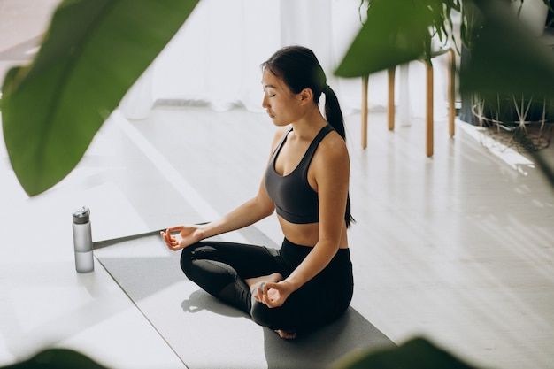 Free photo phụ nữ tập yoga trên thảm ở nhà
