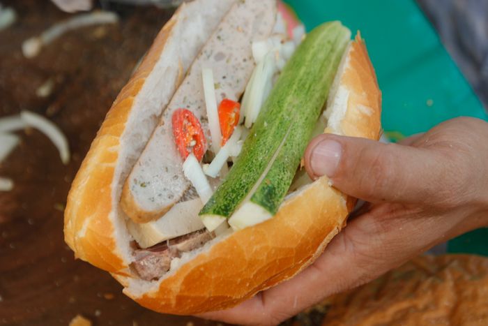 Bánh mì Việt Nam đứng trong top 100 món ăn đường phố hấp dẫn ở châu Á. Hình ảnh một chiếc bánh mì đầy đủ với 5 loại chả, dưa leo, ớt, hành tây, và nước tương - Ảnh: HỒ LAM