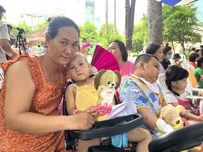 Một em bé mắc bệnh nặng không thể đi lại, không nói được nhưng vẫn say mê theo dõi chương trình trên sân khấu - Ảnh: THÙY DƯƠNG