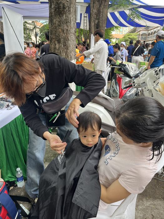 Một em bé mắc bệnh viêm phổi đang được cắt tóc - Ảnh: THÙY DƯƠNG