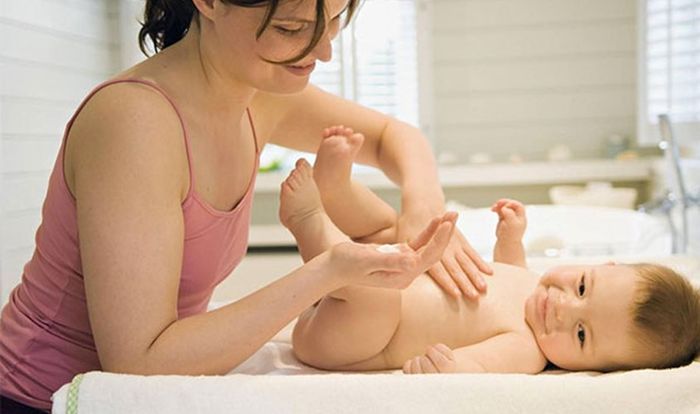 Thoa phấn rôm lên em bé trước khi thay bỉm
