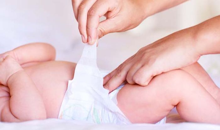 Gỡ miếng dán ở hai bên của tã để dán lên phần trước