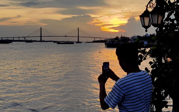 Thưởng thức cảnh đẹp của cầu Rạch Miễu trong buổi chiều tà - (Ảnh: QUÂN NAM)