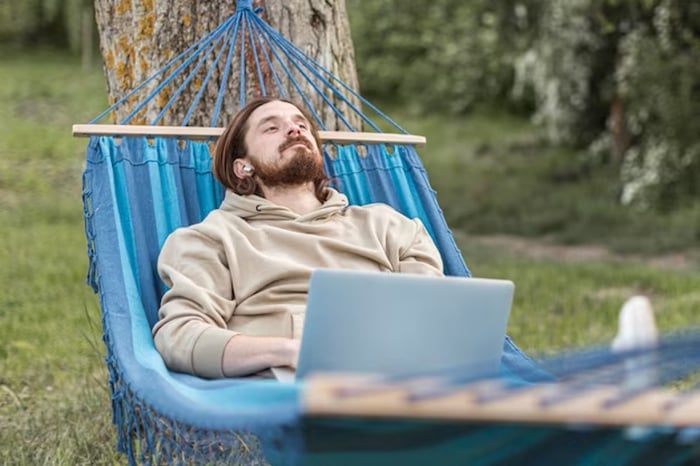 The gentleman is relaxing on a hammock