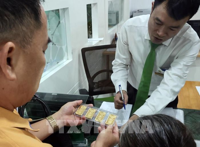 Người dân mua vàng SJC tại Vietcombank, 72 Trần Hưng Đạo, Hà Nội. Ảnh: Trần Việt - TTXVN