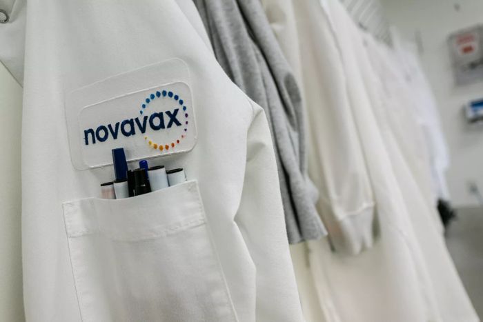 Một biểu trưng của Novavax xuất hiện trên một áo khoác trắng phía trên một túi đựng nhiều cây viết.