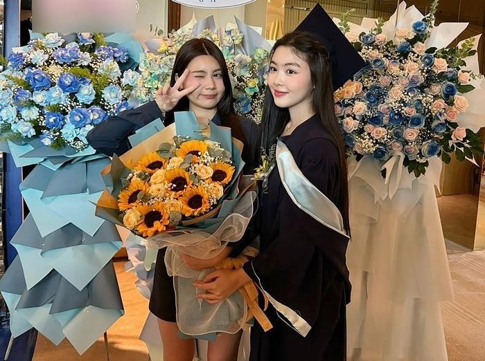 Hạt Dẻ, 15 tuổi, mang hoa chúc mừng chị gái tốt nghiệp. Trên mạng xã hội, nhiều người để lại bình luận khen ngợi nhan sắc của chị em Lọ Lem và Hạt Dẻ.