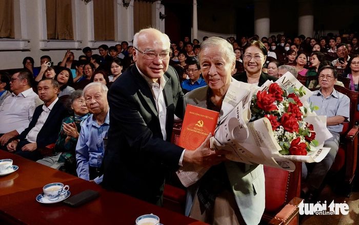 Ông Phan Nguyễn Như Khuê - trưởng ban Tuyên giáo Thành ủy TP.HCM - trao tặng hoa cho nhạc sĩ Trần Long Ẩn - Ảnh: T.T.D.