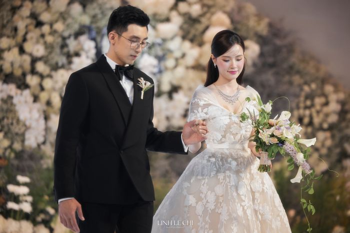 Trước giờ G, Midu và chồng doanh nhân thử đồ tại trung tâm tiệc cưới. Midu mặc váy trễ vai, họa tiết thêu hoa nổi màu trắng.