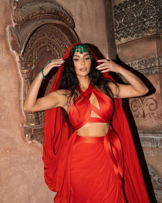 Tại lễ ban phước của 'siêu đám cưới' nhà tỷ phú giàu nhất châu Á, Kim Kardashian tỏa sáng với bộ trang phục độc đáo từ Gaurav Gupta Couture màu cam, kết hợp với những viên ngọc lục bảo Colombia to đùng.