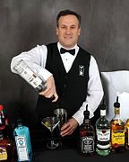 Một bartender đang rót vodka vào bình lắc cocktail