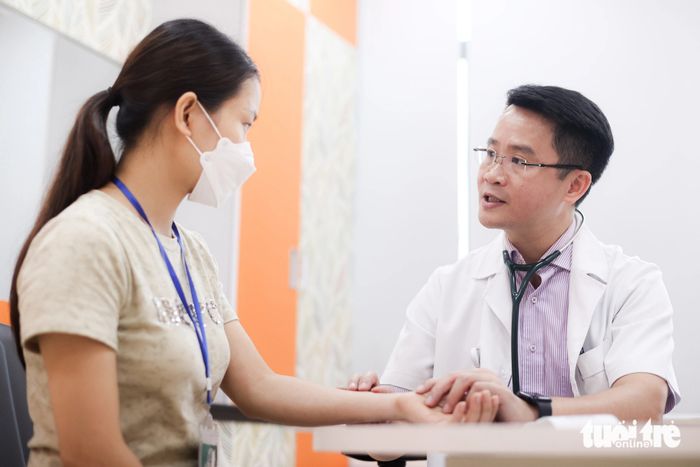 Tiến sĩ, bác sĩ Hoàng Việt Anh (Viện Tim mạch - Bệnh viện Bạch Mai) đã kiểm tra sức khỏe cho một bệnh nhân ngoài giờ hành chính ngày 1-8 - Ảnh: NGUYỄN KHÁNH