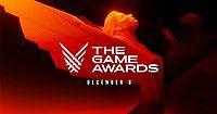 Dòng chữ 'The Game Awards' và 'ngày 8 tháng 12' nằm phía trước bức tượng nhỏ màu cam trên nền đen.