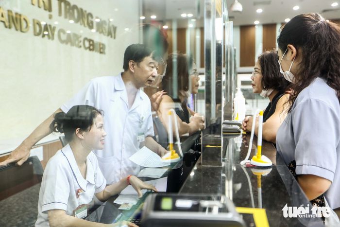 Bệnh nhân và người nhà được nhân viên Khoa khám bệnh hướng dẫn thủ tục khám ngoài giờ theo yêu cầu - Ảnh: NGUYỄN KHÁNH