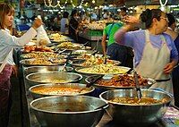 Một gian hàng tại chợ Thanin ở Chiang Mai, Thái Lan, bày bán các món ăn nấu sẵn. Những gian hàng tương tự cũng có thể được tìm thấy khắp Đông Nam Á.