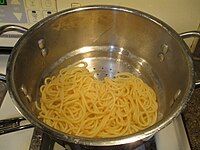 Xả nước từ mì spaghetti sau khi luộc xong.