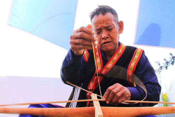 Già làng Cao Văn Thắng (xã Ba Cụm Bắc) đang làm một chiếc nỏ. Ông chia sẻ rằng quá trình chế tạo một chiếc nỏ mất khoảng 2-3 ngày - Ảnh: TRẦN HOÀI
